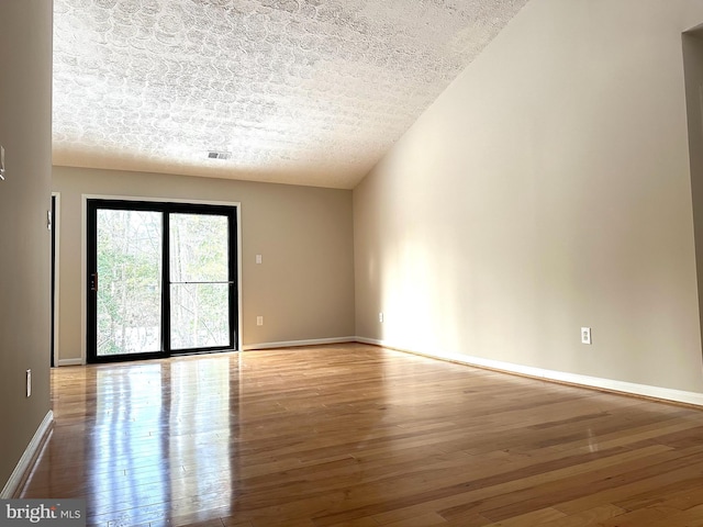 empty room with light hardwood / wood-style floors and a textured ceiling