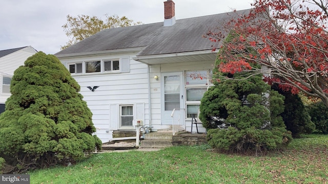 rear view of property featuring a yard