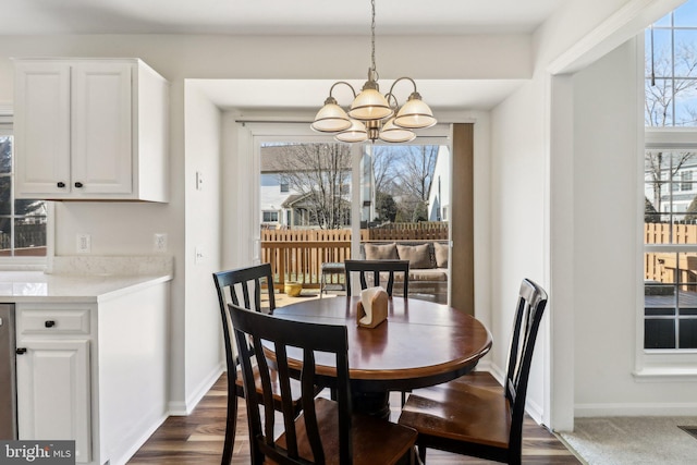 dining area with dark hardwood / wood-style flooring, a chandelier, and a wealth of natural light