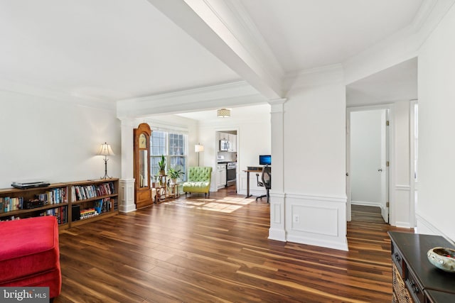 sitting room featuring crown molding, ornate columns, and dark hardwood / wood-style floors