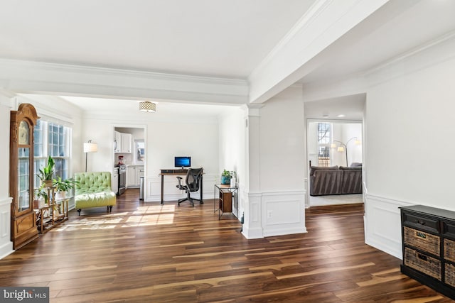 foyer entrance featuring decorative columns, dark hardwood / wood-style floors, and ornamental molding