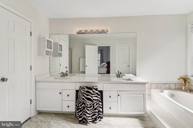 bathroom with vanity and a washtub