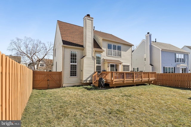 rear view of house with a lawn and a wooden deck