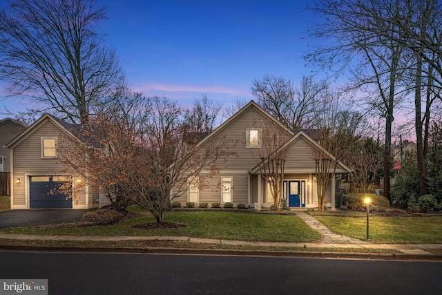 view of front of house with an attached garage, driveway, and a front yard