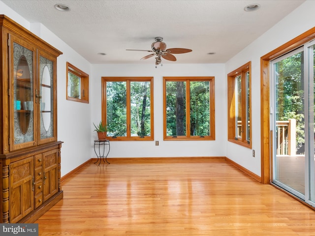 unfurnished sunroom with ceiling fan and plenty of natural light