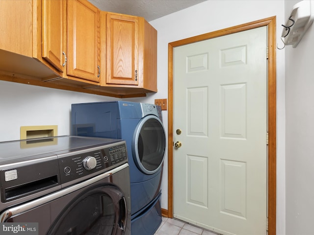 clothes washing area featuring cabinets, light tile patterned flooring, and independent washer and dryer