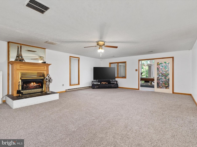 unfurnished living room with ceiling fan, carpet flooring, and a textured ceiling