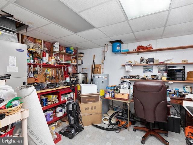 office space with a paneled ceiling and a workshop area