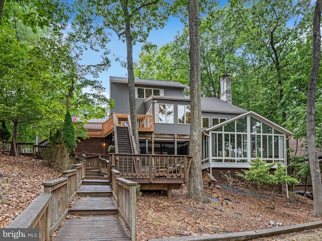 rear view of house with a sunroom and a deck