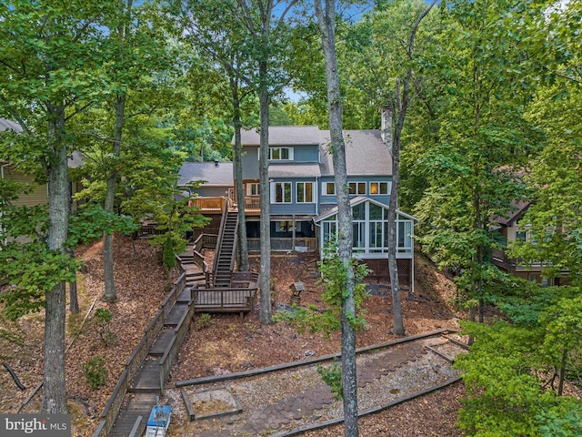 back of house with a wooden deck and a sunroom