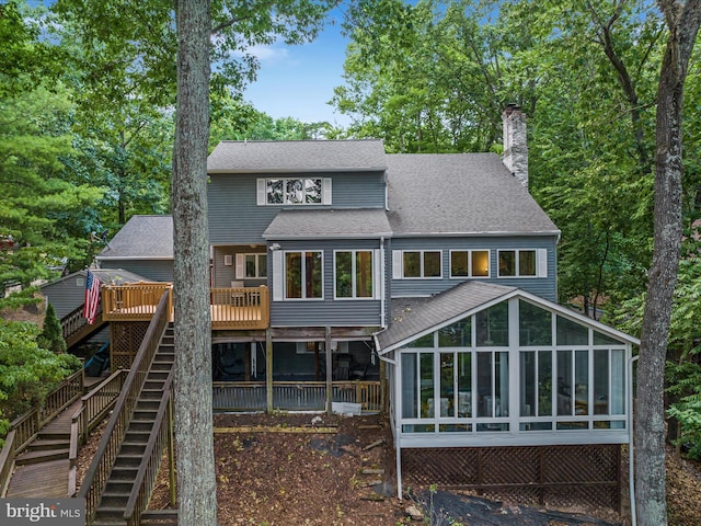 rear view of property featuring a wooden deck and a sunroom