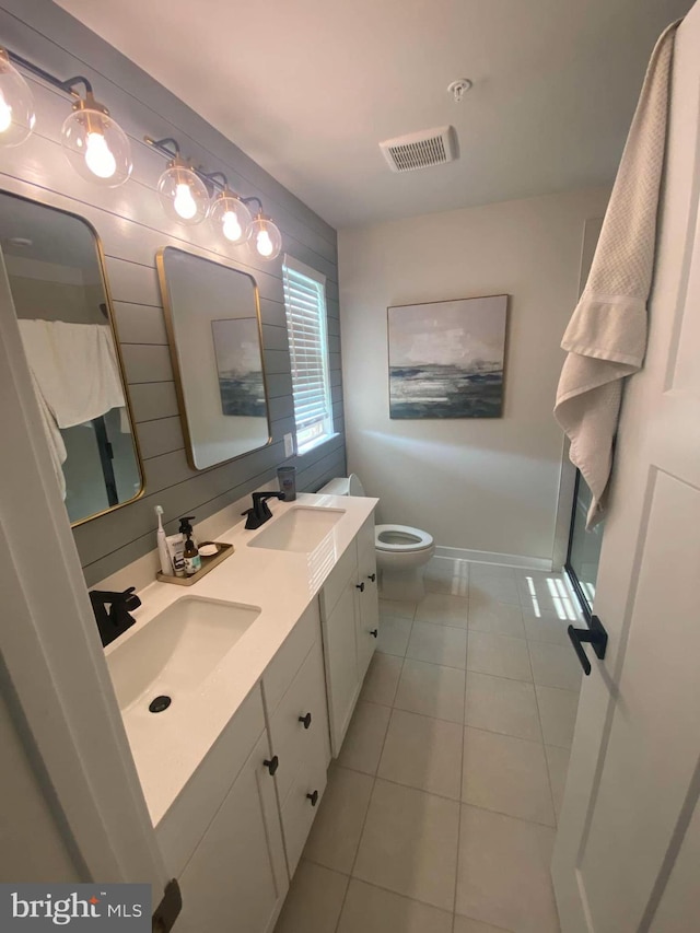 bathroom with vanity, wooden walls, tile patterned floors, and toilet