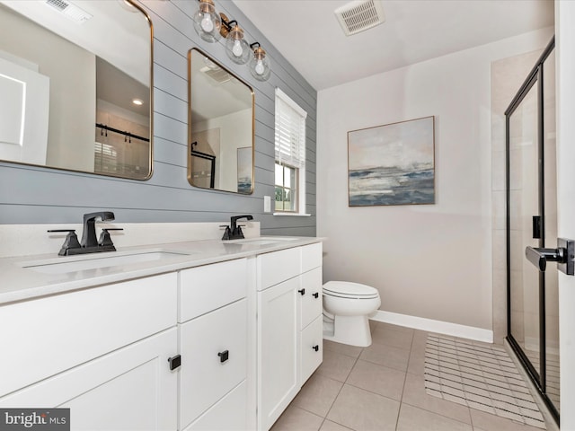 bathroom featuring vanity, toilet, tile patterned floors, and a shower with shower door