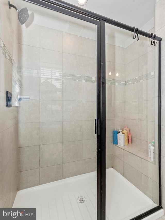 bathroom featuring a shower with door