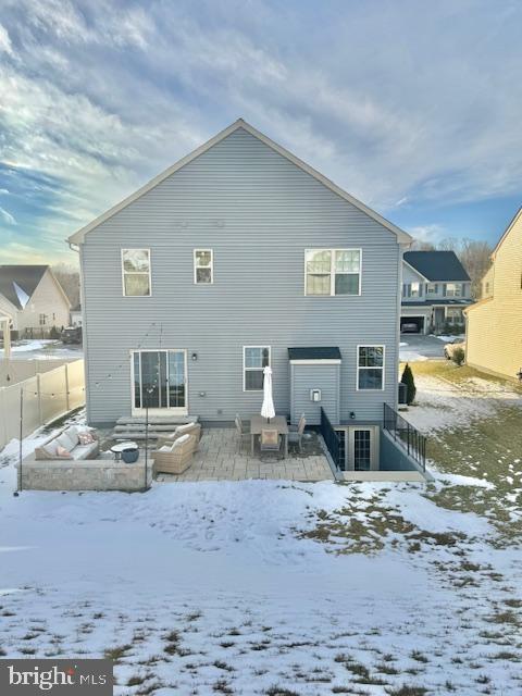 view of snow covered back of property