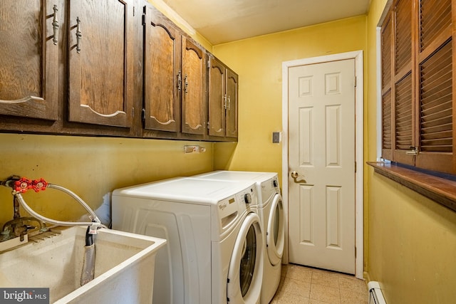 washroom featuring cabinets, a baseboard radiator, sink, and washer and dryer