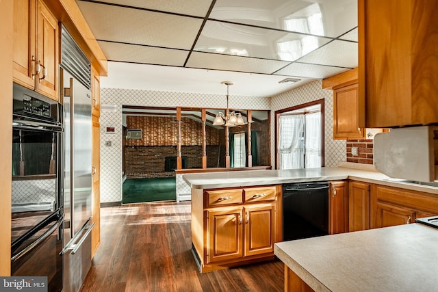 kitchen featuring decorative light fixtures, dark hardwood / wood-style floors, dishwasher, stainless steel built in fridge, and kitchen peninsula