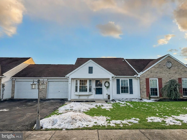 ranch-style house featuring a garage and a front lawn