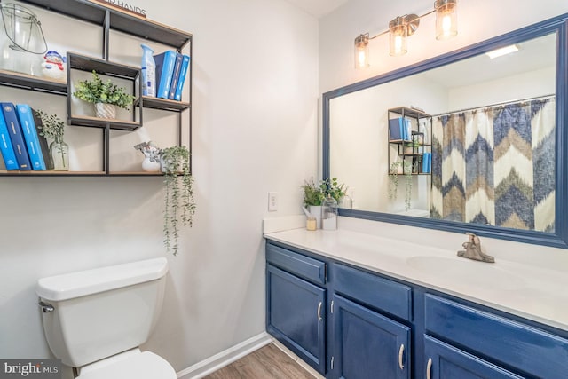 bathroom with vanity, toilet, and wood-type flooring