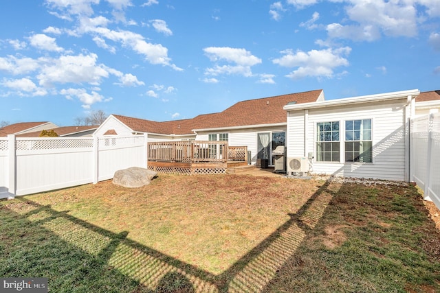 back of property featuring a deck and a lawn