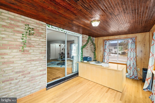 interior space featuring hardwood / wood-style flooring, wood ceiling, brick wall, and wooden walls