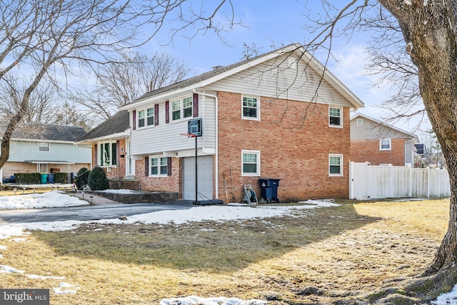 snow covered back of property featuring a garage