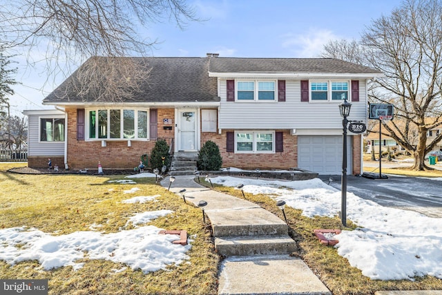 split level home with a garage and a lawn