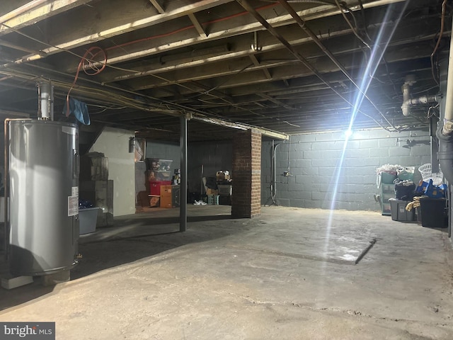 unfinished basement featuring water heater