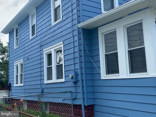 view of side of home featuring fence