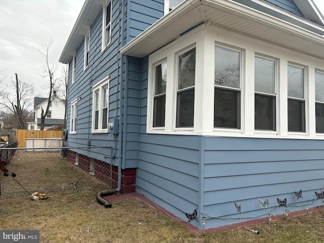 view of side of home featuring fence