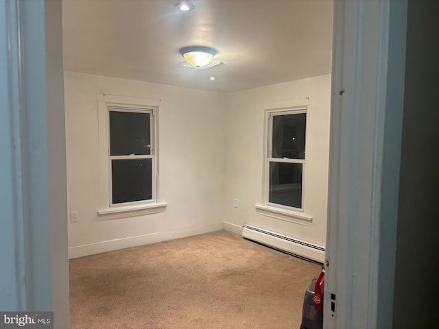 empty room featuring baseboards, carpet floors, and a baseboard radiator