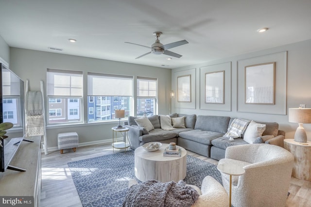 living room with light hardwood / wood-style floors and ceiling fan