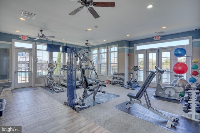 workout area with light hardwood / wood-style floors and french doors