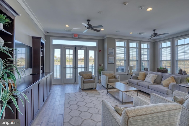 living room featuring crown molding, plenty of natural light, ceiling fan, and light hardwood / wood-style floors