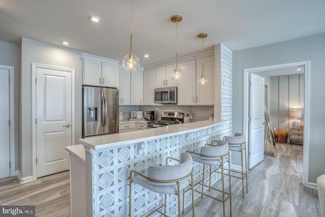 kitchen featuring kitchen peninsula, white cabinets, and appliances with stainless steel finishes