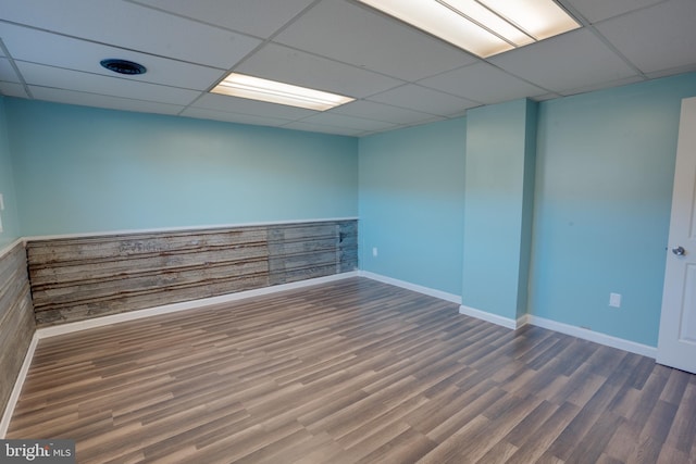 spare room featuring hardwood / wood-style flooring and a drop ceiling