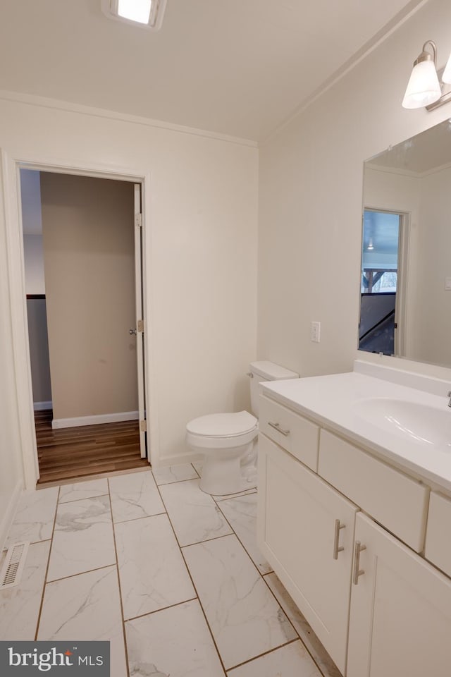 bathroom featuring ornamental molding, toilet, and vanity