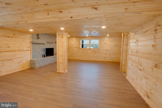 basement featuring hardwood / wood-style floors, wooden walls, wooden ceiling, and a fireplace