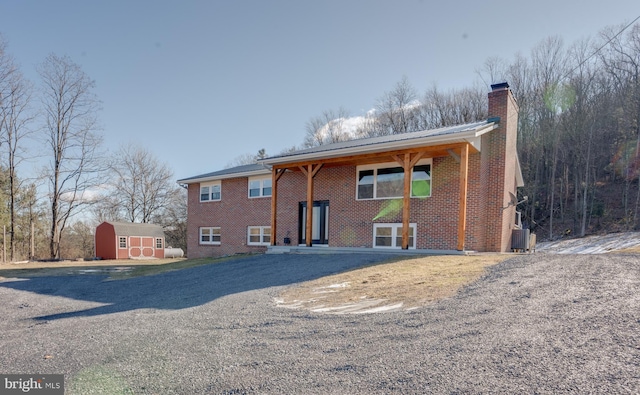 view of front of home with central AC and a storage shed