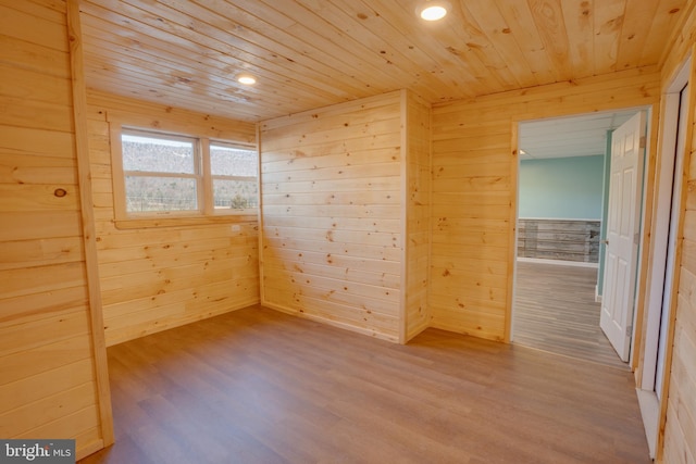 unfurnished room with wood ceiling, wooden walls, and hardwood / wood-style flooring