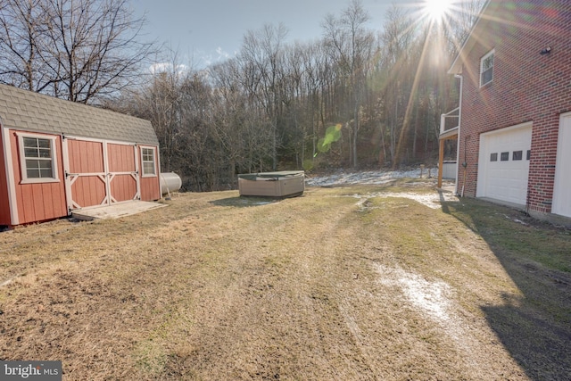 view of yard featuring a hot tub and a shed