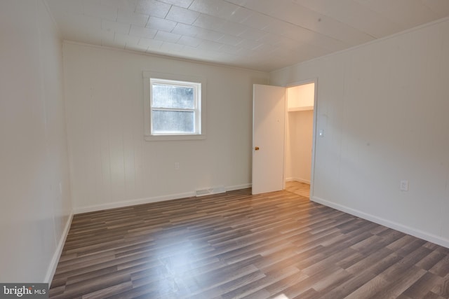 unfurnished room featuring ornamental molding and dark hardwood / wood-style floors