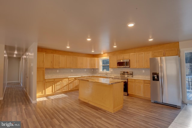 kitchen with sink, a center island, light wood-type flooring, light brown cabinets, and stainless steel appliances