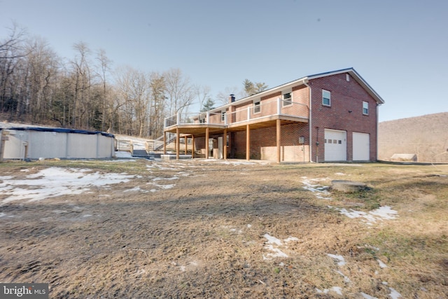 rear view of house with a swimming pool side deck and a garage