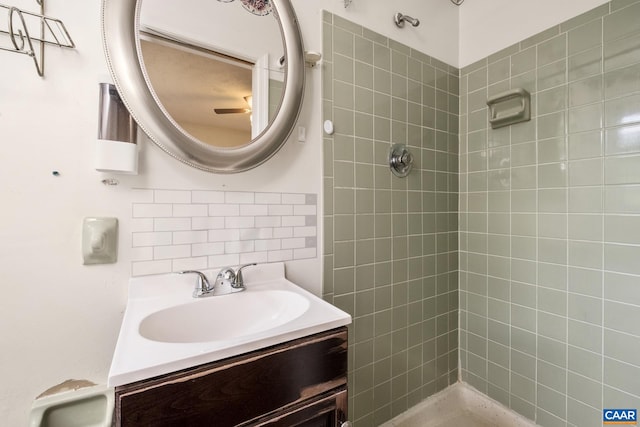 bathroom with vanity, backsplash, and tiled shower