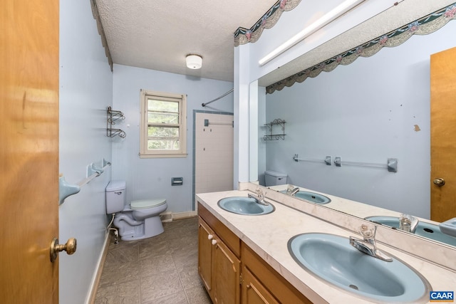 bathroom featuring vanity, toilet, and a textured ceiling