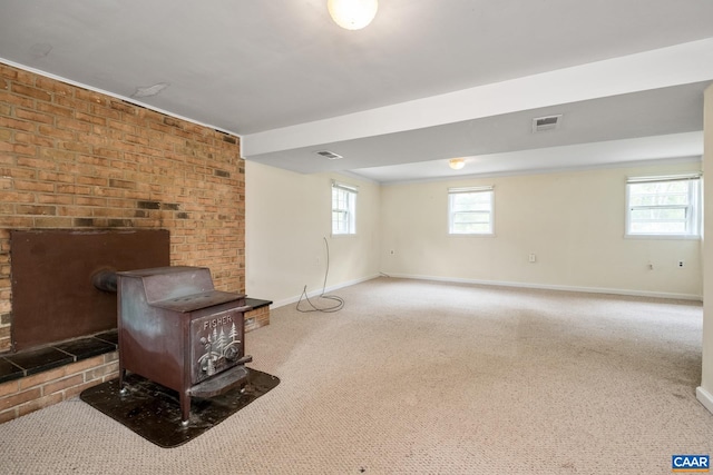 basement featuring carpet floors and a wood stove