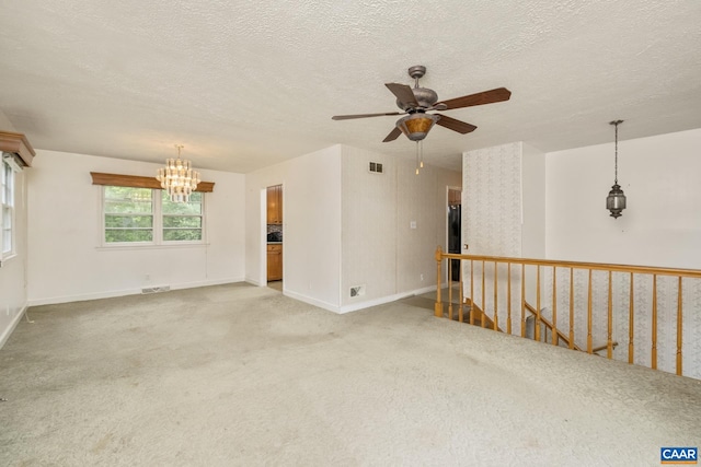 spare room featuring a textured ceiling, a chandelier, and carpet