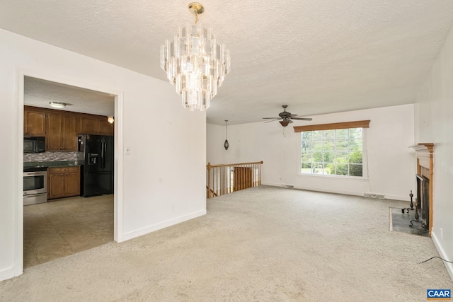 unfurnished living room featuring light carpet, ceiling fan with notable chandelier, and a textured ceiling