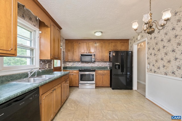 kitchen featuring sink, decorative light fixtures, a textured ceiling, a notable chandelier, and black appliances